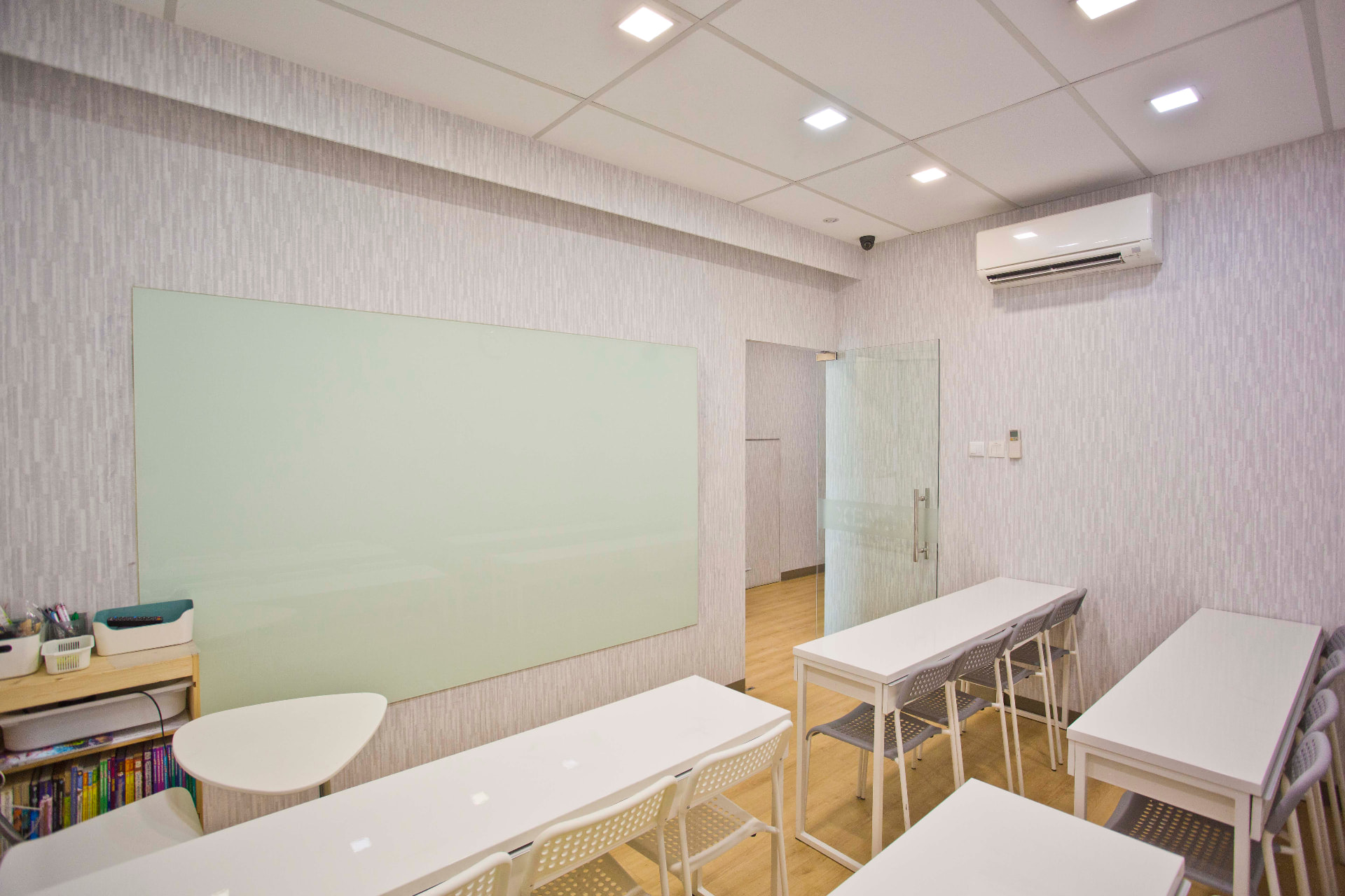 AZKEN classroom with a large whiteboard, white tables and chairs