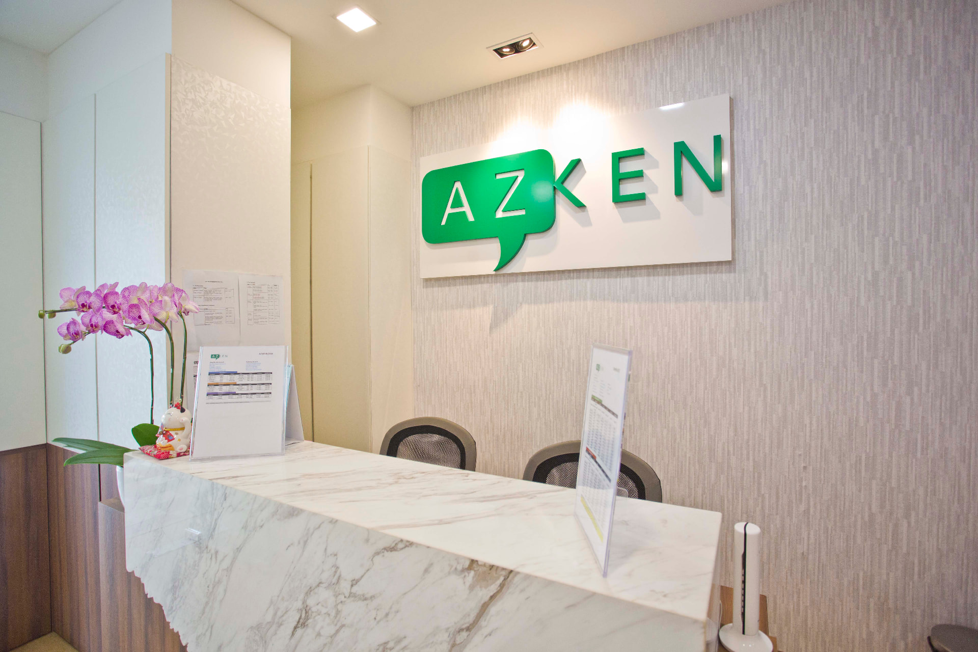 AZKEN reception counter with marble top and the AZKEN logo sign on the wall